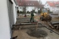 Randsteine fuer die spaetere Holzterrasse werden eingebaut.jpg